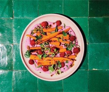 Roasted carrots with raspberries, beet cream, chili oil + cacao nibs