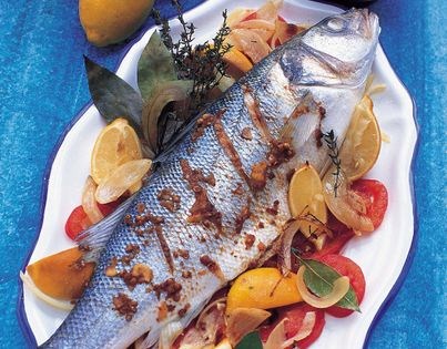 Roasted fish on a bed of lemon sand tomatoes with tahini sauce