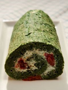 Rolled-up spinach omelet with creamy filling of goat cheese and dried tomato