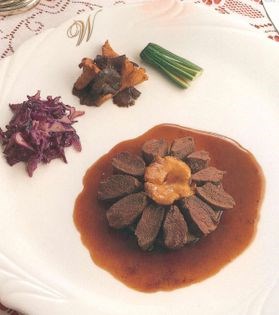Saddle of hare on a base of forcemeat and wild mushrooms in a red wine sauce flavoured with rosemary