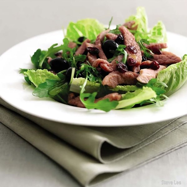 Salad with black olives, sautéed gammon and dried cranberries