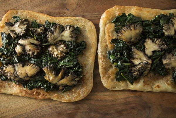 Sautéed mushrooms on flatbread with braised greens