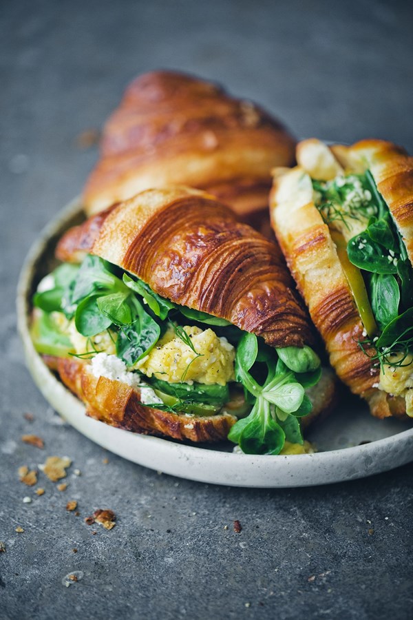 Savory croissants with scrambled eggs, labneh and greens