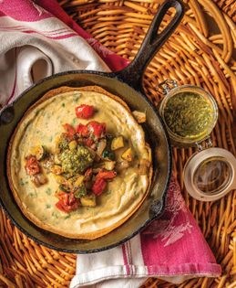 Savory Dutch baby with sautéed vegetables and pesto