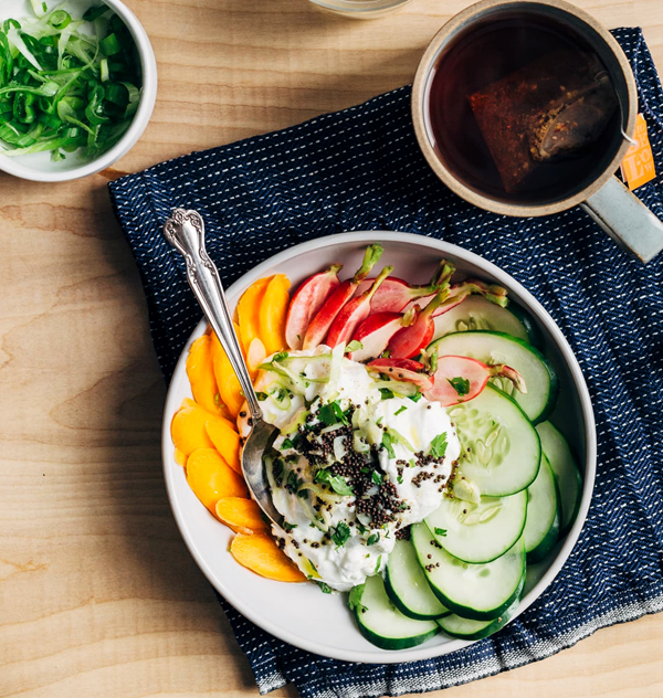 Savory yogurt bowl with sliced veggies and fried mustard seeds