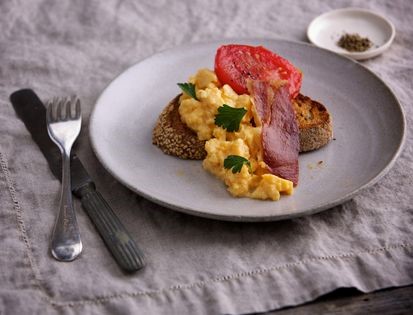 Scrambled eggs on toast with crisp pancetta and confit tomatoes