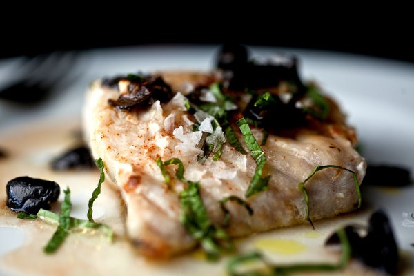 Seared blackfish with tomato water, herbs and olives