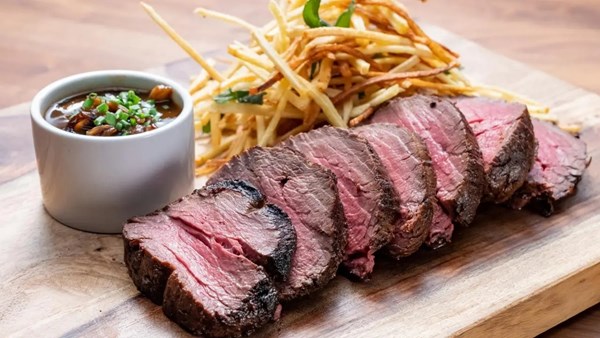 Seared center-cut filet mignon with mushroom demi-glace sauce and herby shoestring potatoes