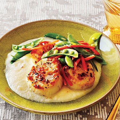 Seared scallops with cauliflower puree with tarragon carrots and peas