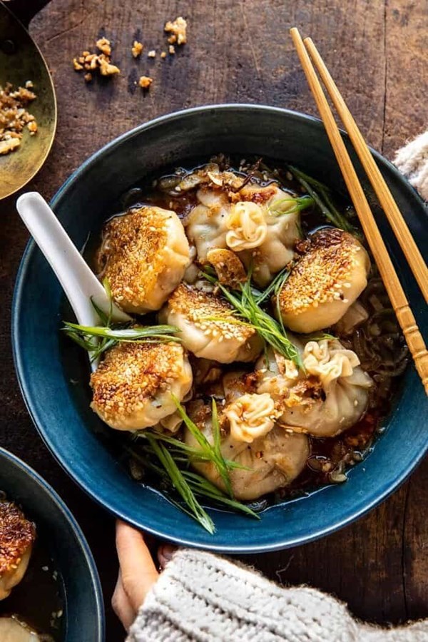 Sesame chicken dumplings in spicy broth with garlic crisps