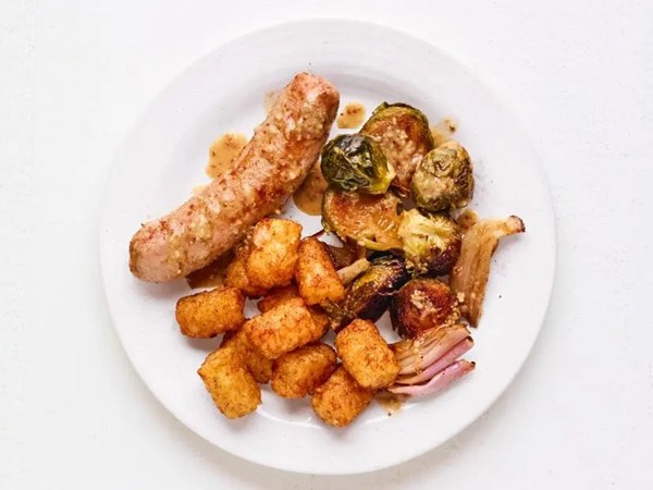 Sheet-pan bratwurst and Brussels sprouts with Tater Tots
