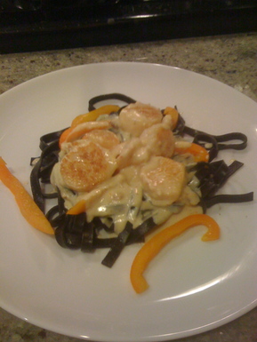 Shrimp and scallops in saffron cream with black pasta