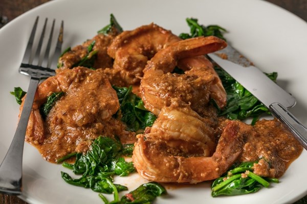 Shrimp cooked in Romesco with wilted spinach