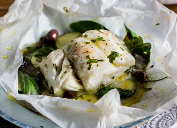 Skrei en papillote with olives, spinach and herbs
