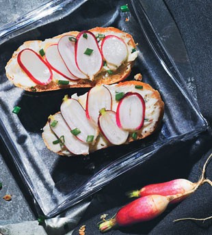 Sliced baguette with radishes and anchovy butter