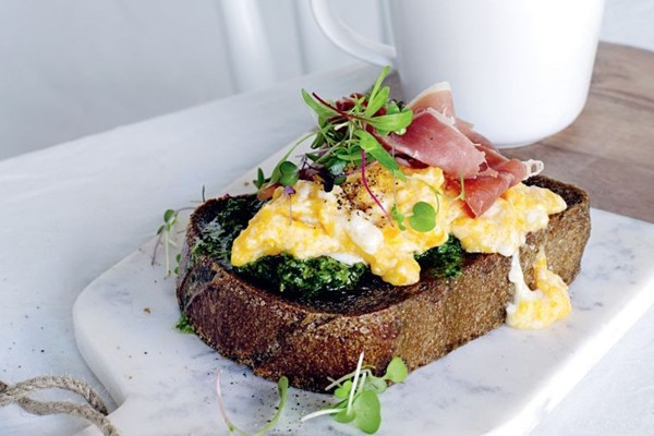 Soft scrambled eggs with kale pesto and prosciutto