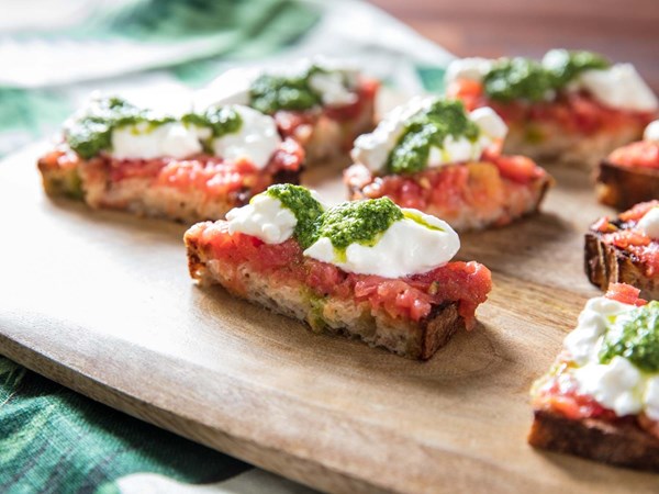 Sourdough toasts with tomato, pesto, and burrata