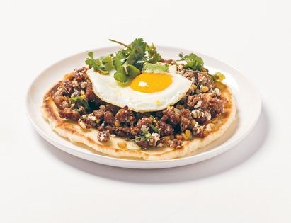 Spiced lamb pizza w fried egg, hummus + lemon