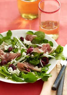 Spicy greens with fresh cherries, prosciutto, and goat cheese