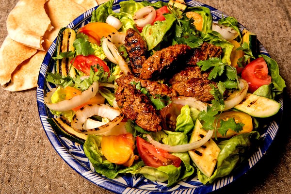 Spicy lamb sausage with grilled onions and zucchini