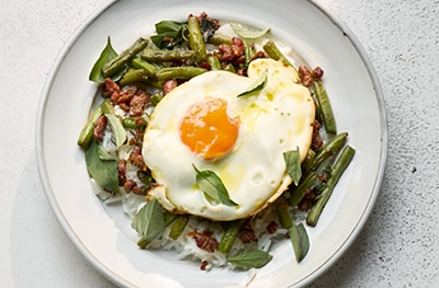 Spicy stir-fried sausage & beans with crispy egg