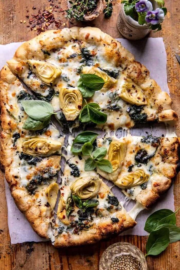 Spinach and artichoke pizza with cheesy bread crust