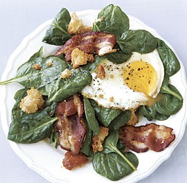 Spinach salad with fried egg and bacon
