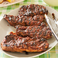 St. Louis barbecued pork steaks on a charcoal grill