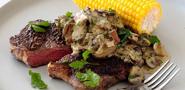 Steak with creamy mushroom, bacon and garlic sauce