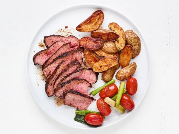 Steak with roasted potatoes and buttery tomatoes