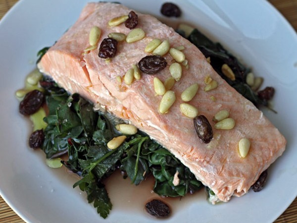 Steamed salmon with chard, pine nuts, and raisins