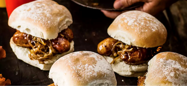 Sticky sausage baps with beer-braised onions