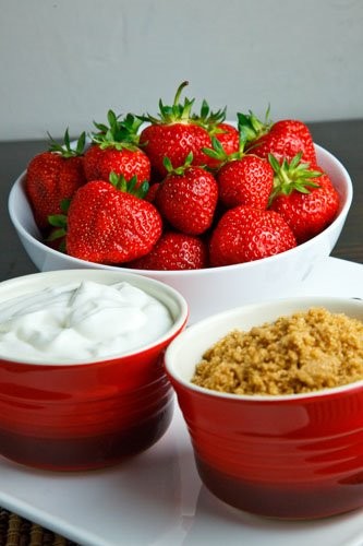 Strawberries dipped in sour cream and brown sugar