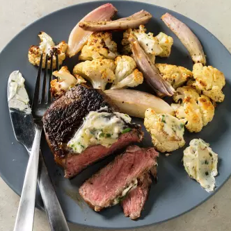 Strip steaks with cauliflower and roasted garlic butter