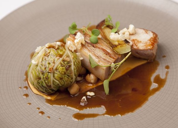 Suckling pig with chou farci, hummus and chickpea fricassee