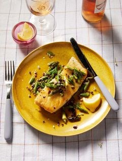 Summer fish with garlic scapes and flowering herbs