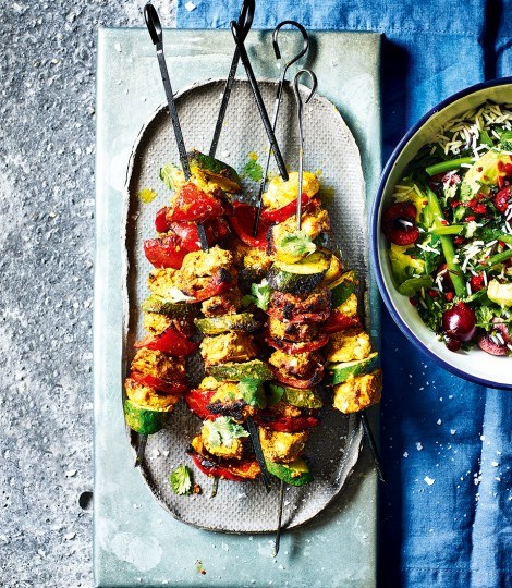 Tandoori-style chicken skewers with green rice and cherry salad
