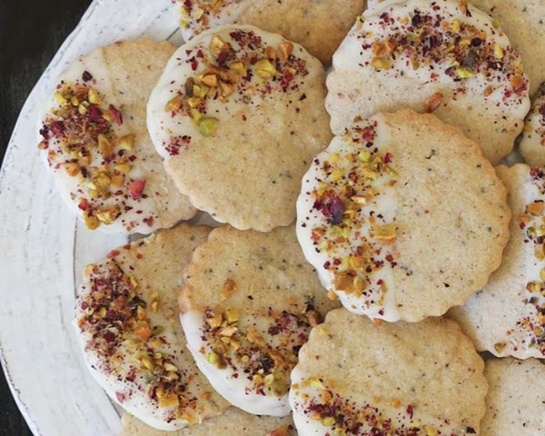 Thandai shortbread cookies dipped in white chocolate with pistachios and rose petals