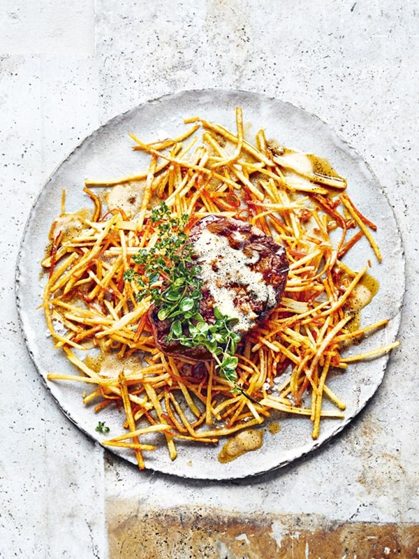 Thick-cut grilled steak with crispy potato, burnt butter and oregano