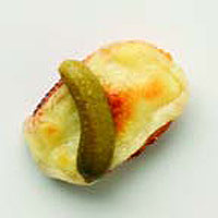 Toasted raclette on baguette rounds, with cornichons
