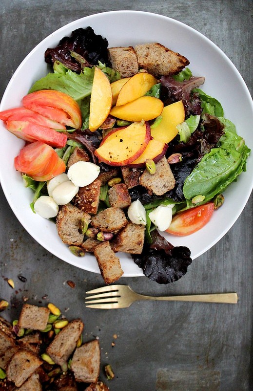 Tomato and peach salad with buttered bread and pistachios