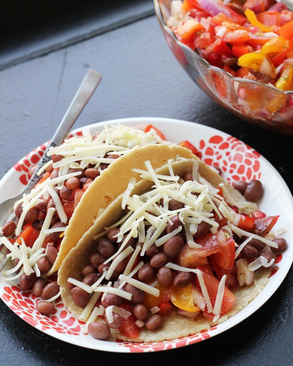 Tomato and pomegranate salad tacos with garlic dressing