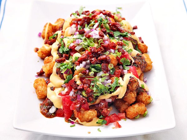 Totchos (Tater Tot nachos) with cheese sauce, charred tomato salsa, chorizo, and pickled jalapeños