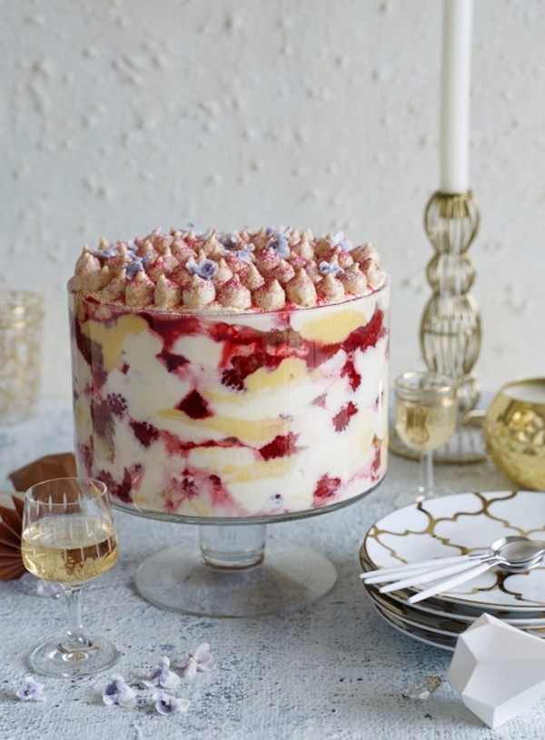 Trifle layered with lemon cream and raspberries with baby meringue topping