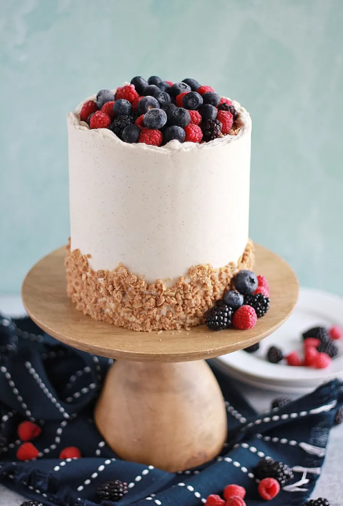 Triple berry cobbler cake with cinnamon vanilla bean buttercream, berry filling, and oatmeal crumble