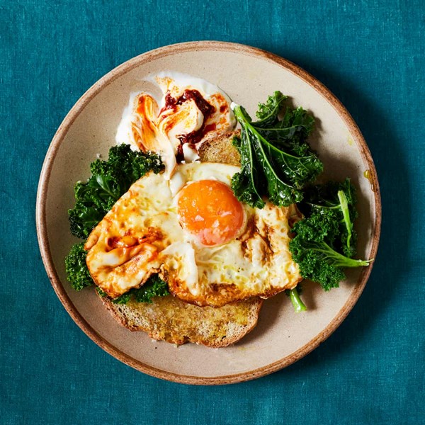 Turmeric fried eggs with kale, harissa yoghurt and soda bread