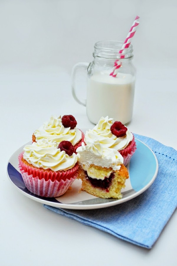 Vanilla cupcakes with clotted cream and raspberry jam