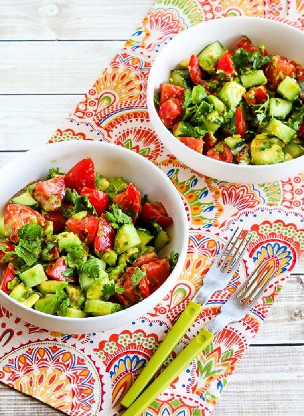 Vegan tomato salad with cucumber, avocado, cilantro, and lime