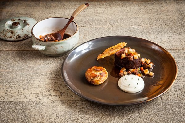 Venison loin with parsnip purée, suet dumpling and sausage casserole