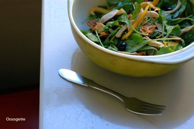 Warm chicken salad with arugula, olives, and pine nuts